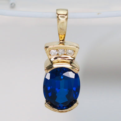 Blue synthetic sapphire and diamond pendant in 14k yellow gold