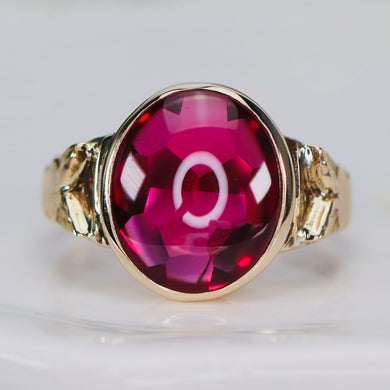 Smooth top oval synthetic ruby ring in yellow gold