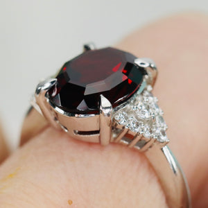 Step cut 4.34ct oval garnet and diamond ring in platinum