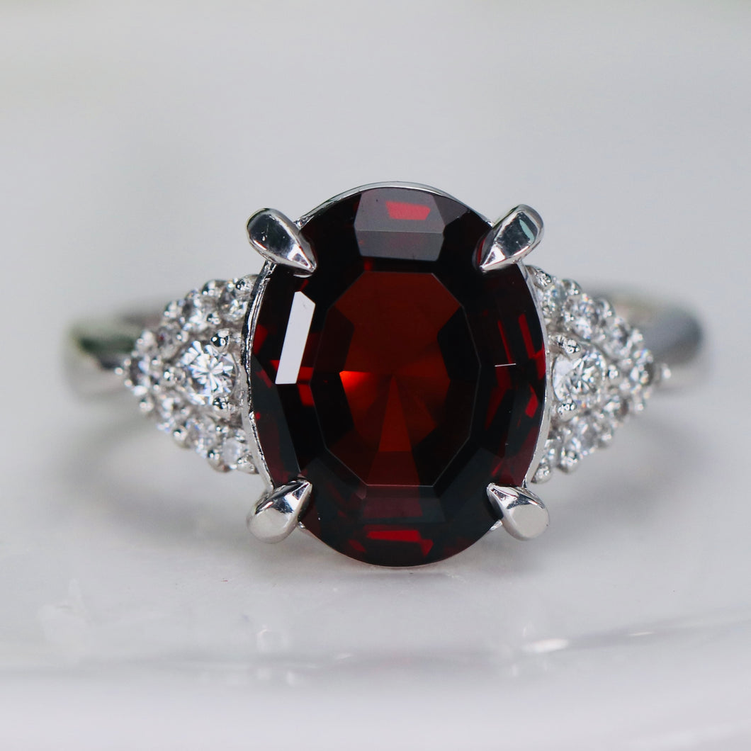 Step cut 4.34ct oval garnet and diamond ring in platinum