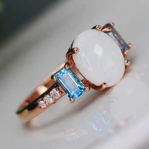 Opal and blue topaz ring in rose gold